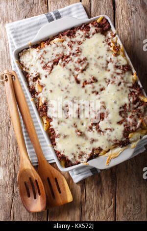 La deliziosa e abbondante pasto: milioni di dollari casseruola di pasta con carne e formaggio in una teglia vicino sul tavolo. verticale in alto vista da sopra Foto Stock