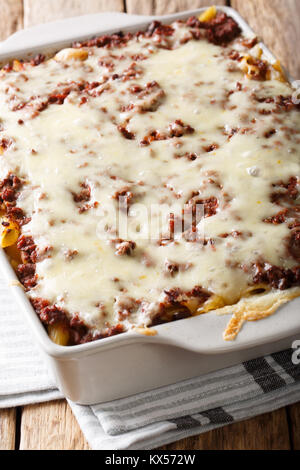 Milioni di dollari di pasta cotto in casseruola con carne e formaggio in una teglia close-up su una tavola verticale. Foto Stock