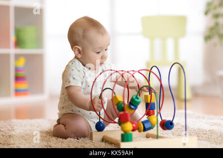 Baby boy giocando con il giocattolo educativo in vivaio Foto Stock