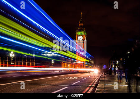 Striature di luce causata da un bus londinese di lasciare i sentieri della luce come pilota sul Westminster Bridge lasciando le case del Parlamento dietro Foto Stock