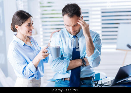 Ottimista donna aiutandola sconvolto collega di rallegrare e relax Foto Stock