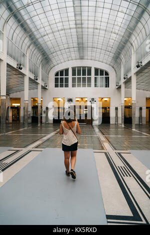 Vienna, Austria - Agosto 17, 2017: Donna alla sala principale di Austrian Postal Savings Bank edificio chiamato Osterreichische Postsparkasse progettato da archi Foto Stock