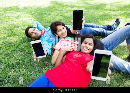 2 Indian ragazze giovani amico insieme giacente erba Parco godendo Foto Stock