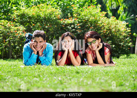 Indian adolescenti studenti del college giacente erba Park Prenota studio educazione Foto Stock