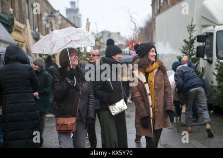 Londra, Inghilterra - dicembre 18 , 2017 giovane camminando per la strada a parlare al telefono in caso di pioggia Foto Stock