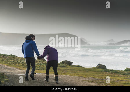 Regno Unito - previsioni del tempo - un giovane lottando per andare a piedi in venti forti durante la tempesta Eleanor in Newquay sulla North Cornwall Coast. Foto Stock