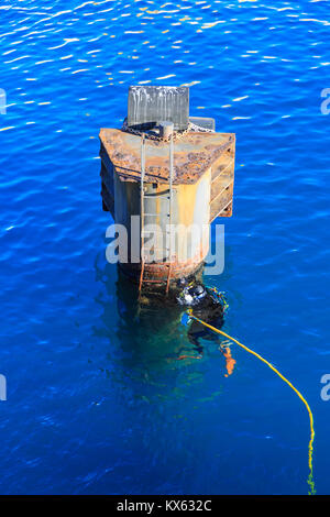 Subacqueo ad esplorare una piattaforma arrugginito e immersioni nell'azur acque blu del mar Mediterraneo, Francia, Europa Foto Stock