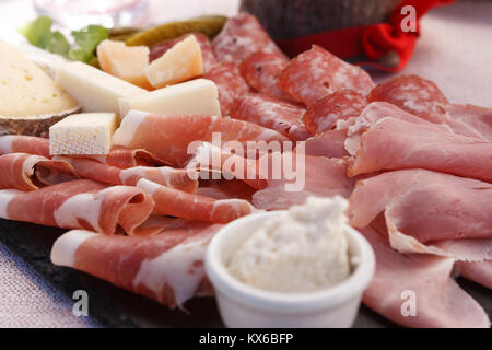 Dettaglio di un piatto di speck e il tipico salame con formaggio e sottaceti, Cortina D'Ampezzo, Italia Foto Stock