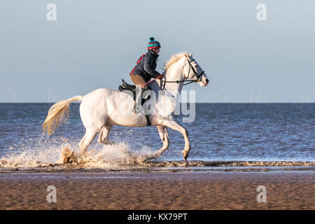 Cavallo Cavaliere, Spiaggia di Cleveleys Lancashire. 8 gennaio 2018. Regno Unito Meteo. Deborah Simmonds mette il suo amato Cavallo, 4 anno vecchio 'Scooby' attraverso i suoi passi come egli trot attraverso la marea entrante nel glorioso sole invernale lungo le rive di Cleveleys beach in Lancashire. Credito: Cernan Elias/Alamy Live News Foto Stock