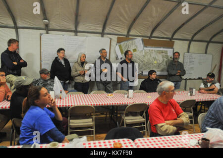 La galena, AK - Volontari e operatori umanitari con la United Methodist volontari in missione ascoltare la mattina in devozionale della tenda da pranzo presso il risponditore Camp in Galena, Alaska, Sett. 9. Il UMVIM volontari venuti a Galena a favore dei residenti in quanto essi ricostruire la primavera seguente inondazioni lungo il fiume di Yukon. Verso la fine di maggio, enormi lastre di ghiaccio intasato Yukon a valle di galena. Il fiume di acqua è aumentato rapidamente e violato le sue banche, inondando la città, distruggendo case, e lasciando in mesi di lavoro di recupero dietro quando le acque si abbassarono. (U.S. La Guardia Nazionale foto di Sgt. 1. Classe Brock Jones, 128t Foto Stock