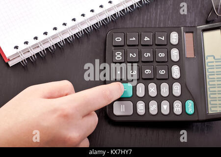 Dito sulla calcolatrice, premendo il pulsante Aggiungi, close up Foto Stock