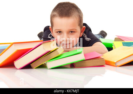 Little Boy con un sacco di libri che giace sul pavimento, isolato su bianco Foto Stock