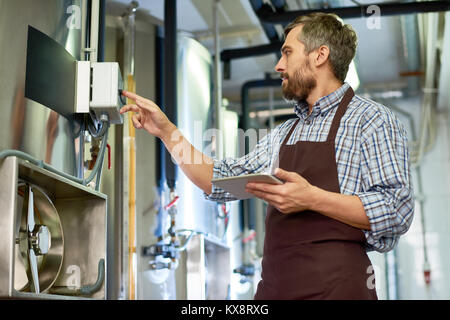 Tecnico barbuto avvolto in un lavoro Foto Stock