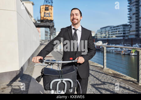 Eco-friendly startup imprenditore spinge una bici attraverso la città