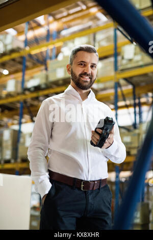 Lavoratore di magazzino o supervisore con uno scanner di codici a barre. Foto Stock