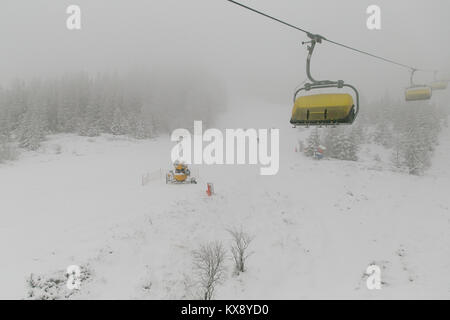 La gente lo sci e lo snowboard sul Skrzyczne mountain dopo la nevicata in una nebbiosa giornata invernale in Szczyrk ski resort in Polonia Foto Stock