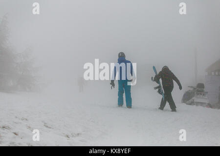 Gli sciatori e gli snowboarder escursionisti che arrivano al coperto di neve e nebbia vertice di Skrzyczne mountain in Szczyrk voce per le piste da sci e sentieri escursionistici Foto Stock