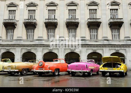 L'Avana, Cuba - 10 dicembre 2016: il vecchio americano auto colorati che servono come taxi per i turisti al fine di andare in un tour di l'Avana vecchia in piedi al cento Foto Stock