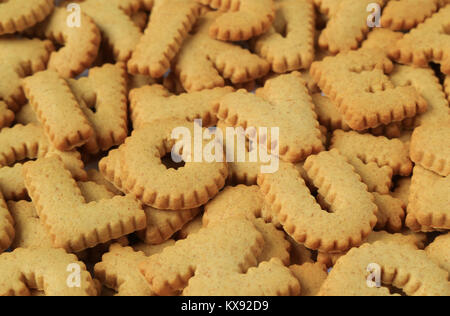 Close-up della parola I LOVE U scritto con alfabeto biscotti sagomato sulla pila di biscotti stesso Foto Stock