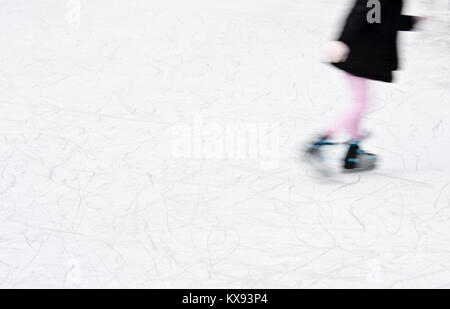 Arty sfocata ragazza pattinaggio su ghiaccio per il divertimento e la ricreazione di inverno Foto Stock