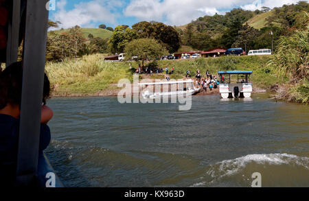 Tourist appoggiata sul lato della barca che stava trasportando passeggeri da La Fortuna di terreni a Monteverde, attraverso il Lago di Arenal, Costa Rica Foto Stock