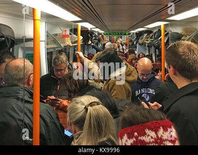 Pendolari cavalcare un affollato South Western Railway treno sul Portsmouth a Londra Waterloo linea come lavoratori in cinque aziende ferroviarie di fase una nuova ondata di scioperi nelle aspre controversie circa il ruolo delle guardie, causando interruzioni ai servizi nella prima settimana completa torna al lavoro dopo la pausa festiva. Foto Stock