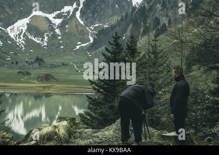 Escursionista in piedi nella parte anteriore del bellissimo lago di montagna di seealpsee, Appenzell, Svizzera Foto Stock