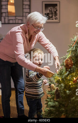 Wheat Ridge in Colorado - Susan Newell, 69, aiuta a suo nipote, Adam Hjermstad Jr., 3, decorare l'albero di Natale. Foto Stock