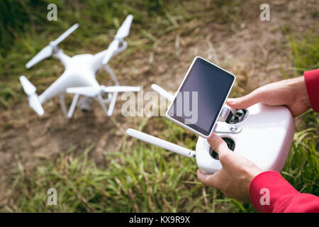 Uomo drone operativo utilizzando un telecomando Foto Stock