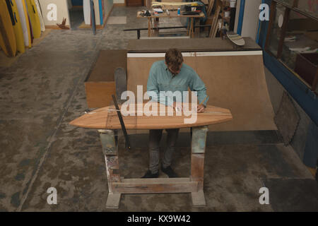 L'uomo la misura con il righello sulla tavola da surf Foto Stock