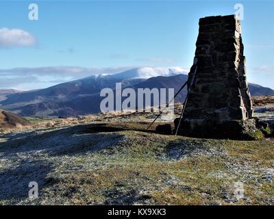 Pali trekking appoggiata sul vertice trig punto, molva cadde, Parco Nazionale del Distretto dei Laghi, Cumbria, Regno Unito Foto Stock