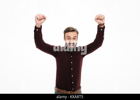 Ritratto di un allegro uomo felice per celebrare il successo con le mani alzate isolate su sfondo bianco Foto Stock