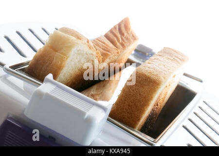 Tostare in un tostapane. Toast fritti fette all'interno del tostapane. Una vista ravvicinata di pasticceria in un dispositivo di tostatura. Foto Stock