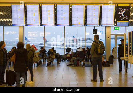 AMSTERDAM, Paesi Bassi - 27 DIC 2017: ci sono persone in attesa alla loro porta per il loro volo sull aeroporto di Schiphol nei pressi di Amsterdam Foto Stock
