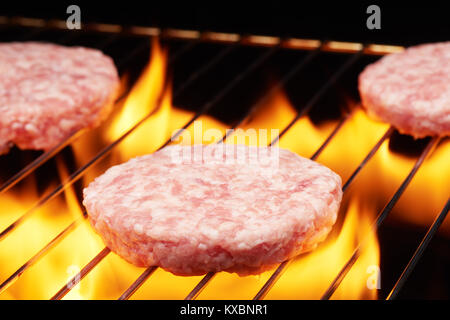 Materie hamburger per la cottura sulla griglia con la fiamma Foto Stock