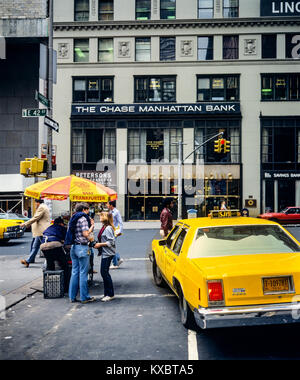 New York 1980s, taxi giallo, Frankfurter salsicce carrello alimentare, persone, la filiale Chase Manhattan Bank, angolo Vanderbilt Avenue e 42nd strada, Manhattan, New York City, NY, NYC, STATI UNITI, Foto Stock