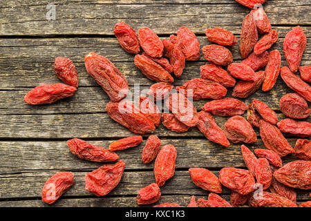 Essiccati goji bacche sul vecchio tavolo in legno. Foto Stock