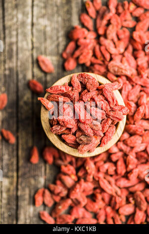 Essiccati goji bacche in vaso su sfondo di legno. Foto Stock