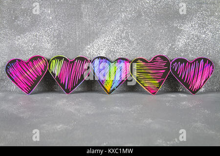 In casa viola nero Cuori rosa su un cemento grigio Sfondo. Il concetto di San Valentino. Un simbolo di amore Foto Stock