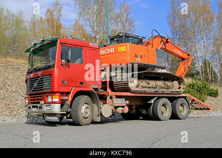 SALO, Finlandia - 26 Aprile 2014: Volvo F12 scambiatore aria-aria traina un HITACHI ZAXIS 110 escavatore. Volvo F12 è stato fabbricato nel 1977-1993, con innovazioni e Foto Stock