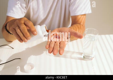 Anziani uomo malato con le pillole in mani. Foto Stock