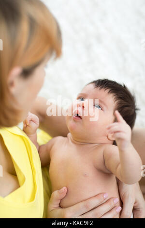 Funny neonato e la mamma cercando ciascuno ad altri Foto Stock