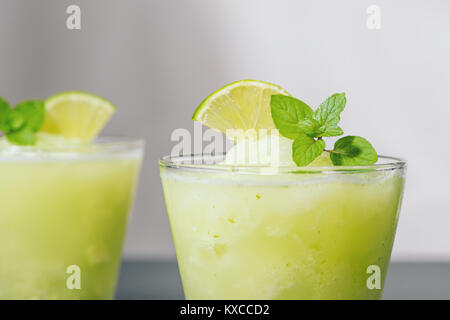 Cocktail con succo di lime, menta e ghiaccio. Drink Bar accessori sulla tavola nera dello sfondo. Foto Stock