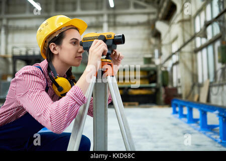 Geodesist femmina lavorando sul sito Foto Stock