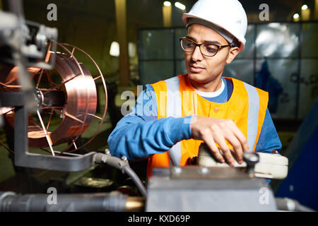 Operatore di macchina avvolto in un lavoro Foto Stock