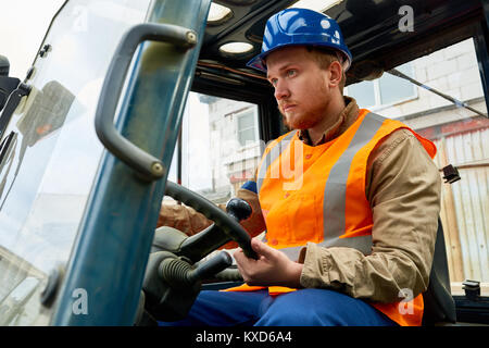 Lavoratore barbuto di guida del carrello di sollevamento Foto Stock