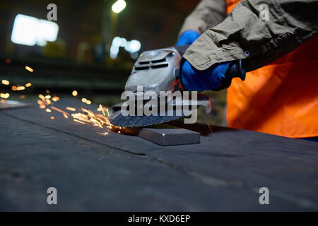 Impianto siderurgico lavoratore utilizzando Smerigliatrice angolare Foto Stock