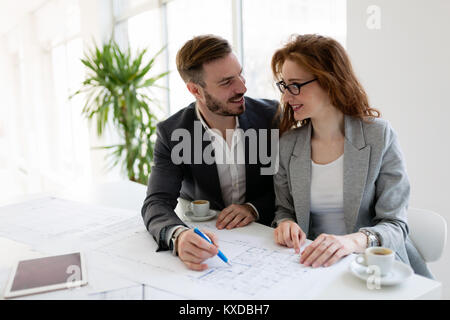 Attraente di giovani architetti che lavorano sul progetto in ufficio Foto Stock