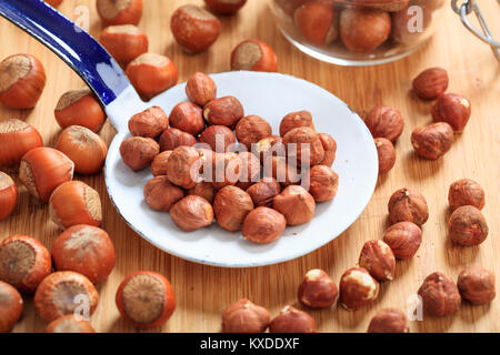 Le nocciole e un vecchio mestolo su un tavolo Foto Stock