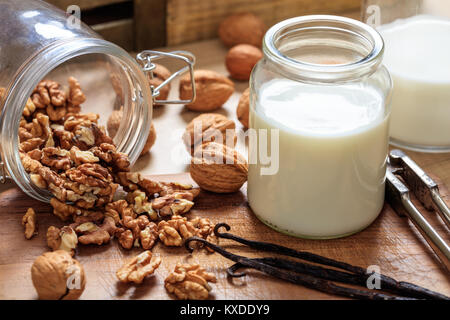 Latte vegano da noci su una superficie in legno Foto Stock